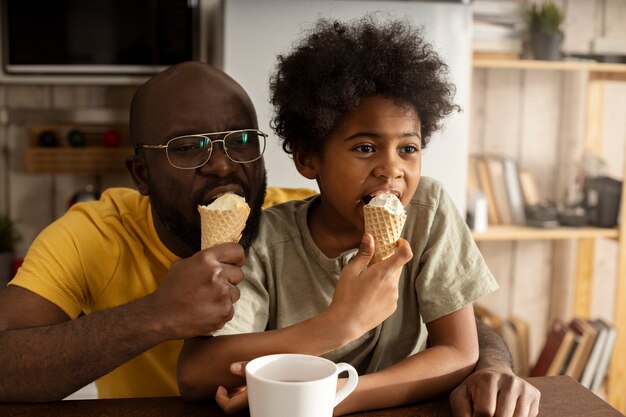 台所で一緒にアイスクリームを持っている父と息子