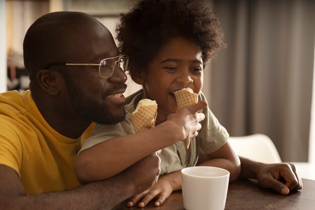 Father and son having ice cream together in the kitchen