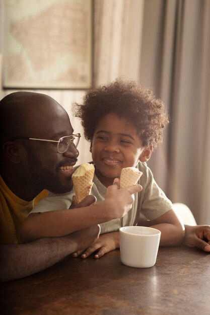 Father and son having ice cream together in the kitchen
