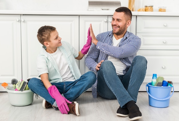 Father and son high-fiving each other during house cleaning