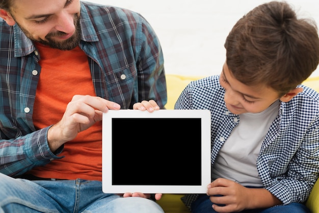 Free photo father and son holding a mock up photo