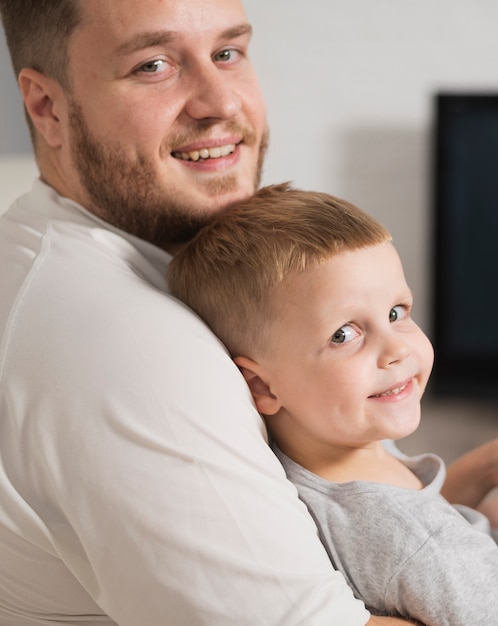 Father and son at home looking at camera