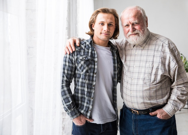 Foto gratuita padre e figlio che abbracciano in piedi a casa