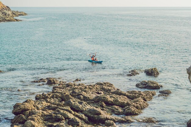 Father and son kayaking at tropical ocean.