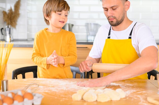 Father and son knead the dough with bare hands