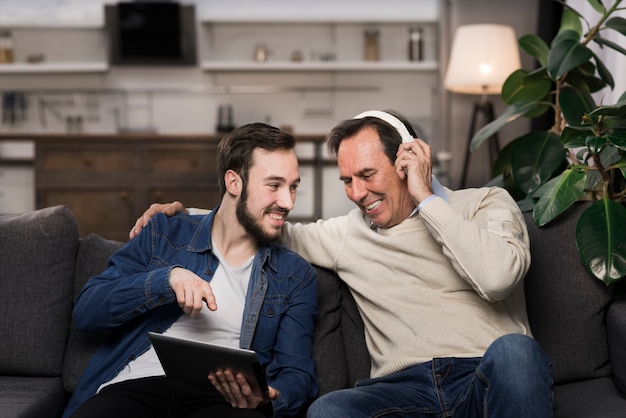 Father and son laughing and looking at tablet