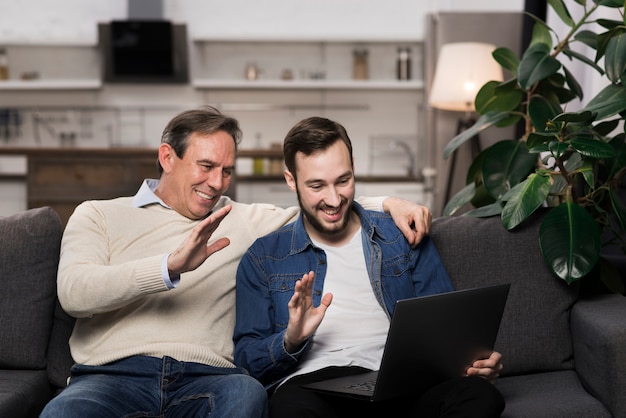 Free photo father and son looking at laptop