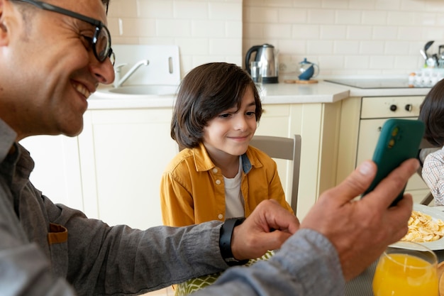 Free photo father and son looking at a smartphone at home