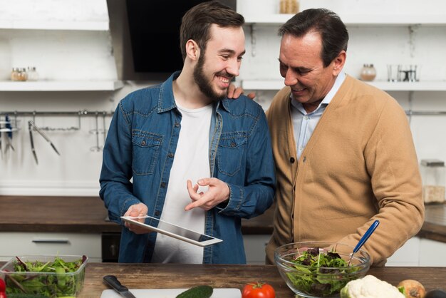 Father and son looking at tablet in kitchen