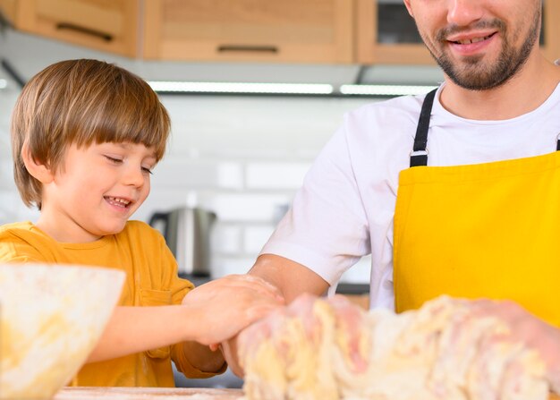 Father and son making dough close-up