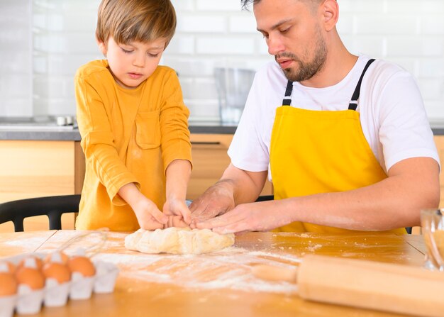 Father and son making dough in the kitchen