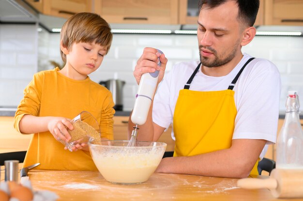 父と息子がミキサーの正面図で生地を作る