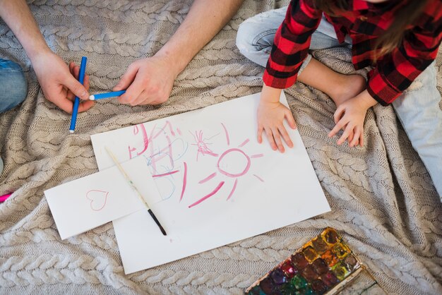 Father and son painting with crayons