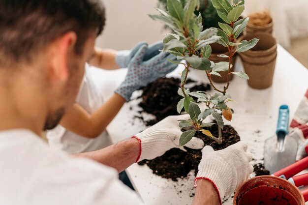 父と息子が家の鉢に一緒に植える