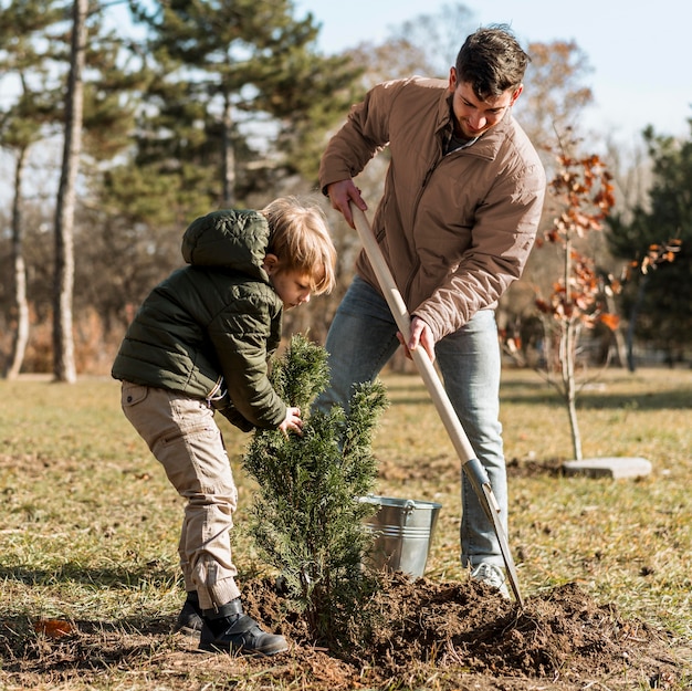 Free photo father and son planting a tree together