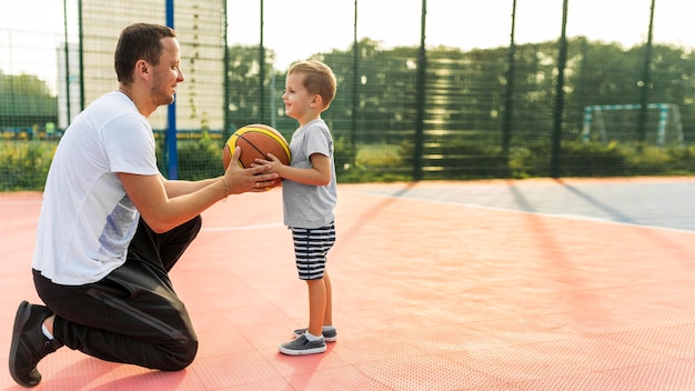 Отец и сын играют на баскетбольном поле