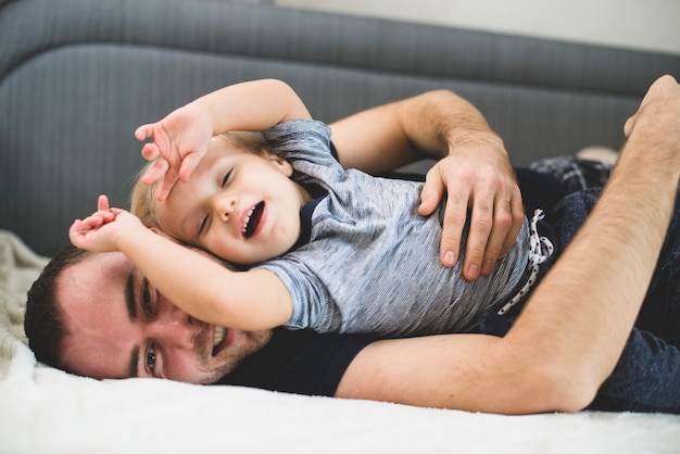 Free photo father and son playing on the floor