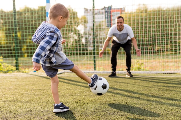 Free photo father and son playing football