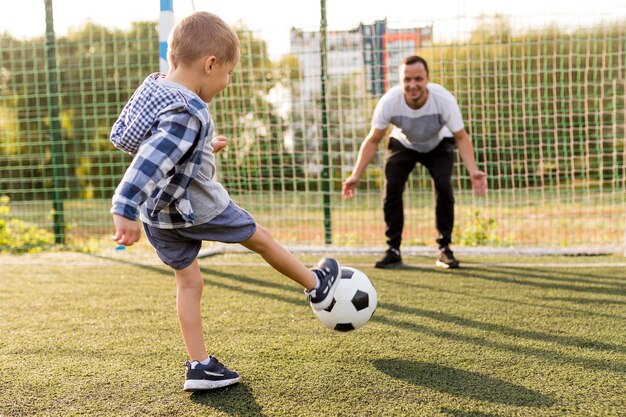Отец и сын играют в футбол