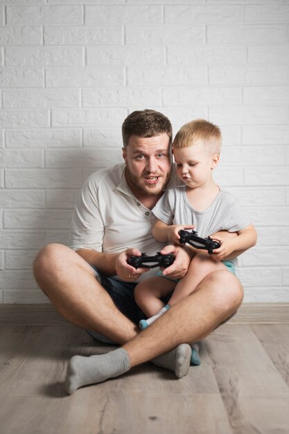 Father and son playing together with joystick