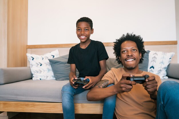 Father and son playing video games together at home.