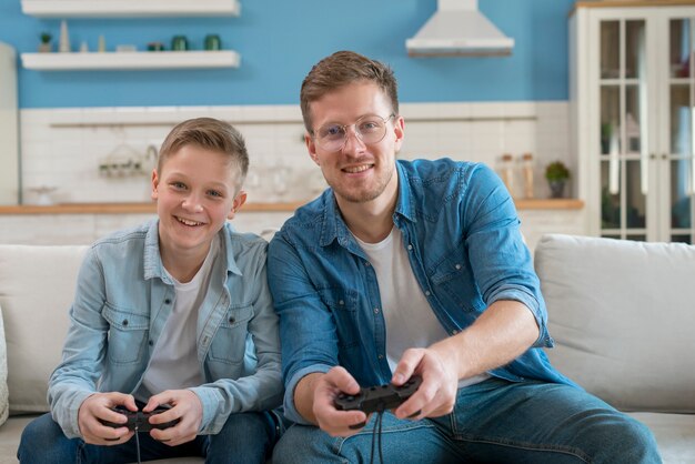Отец и сын играют в видеоигры с контроллерами