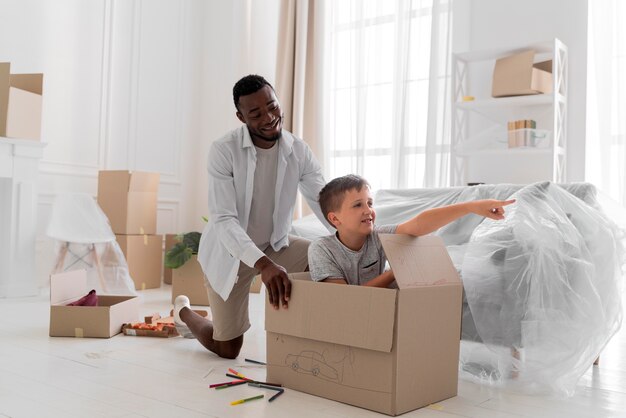 Father and son playing with a box while moving