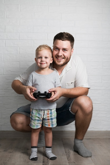 Father and son playing with joystick at home