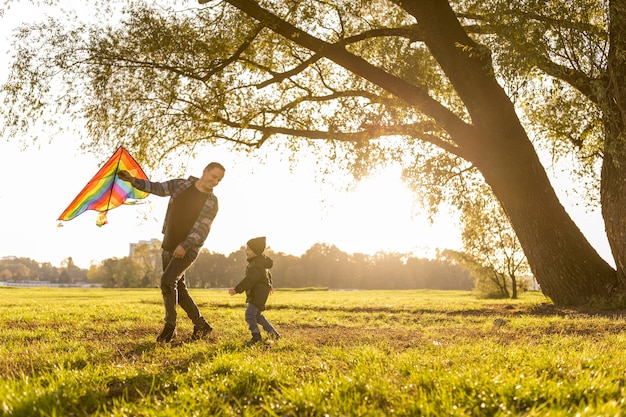 Father and son playing with a kite in park