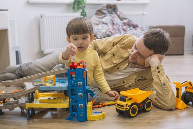 Father and son playing with toy cars