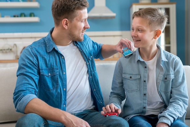 Father and son playing with toy cars