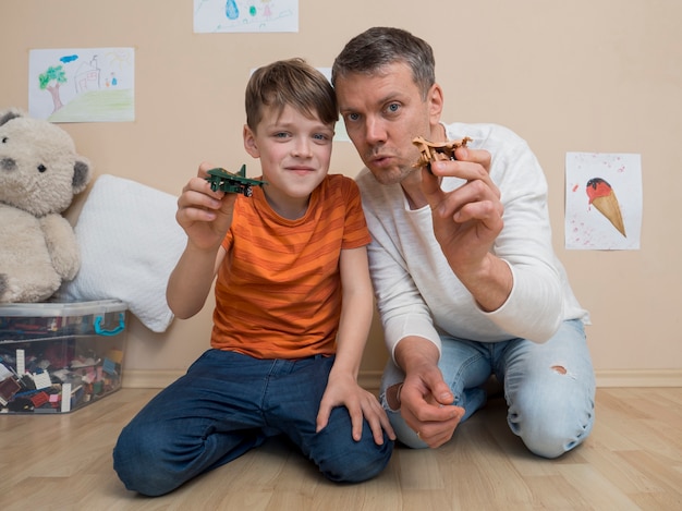 Free photo father and son plying with plane toys