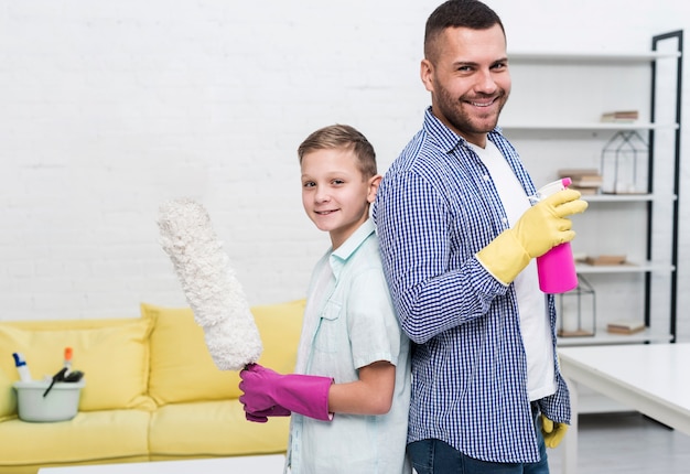 Father and son posing back to back with cleaning products