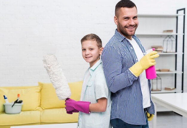 Father and son posing back to back with cleaning products