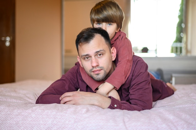 Free photo father and son posing on bed