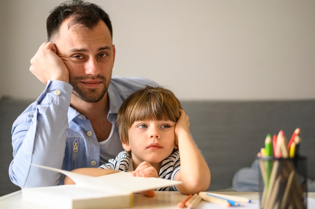 Father and son posing with book