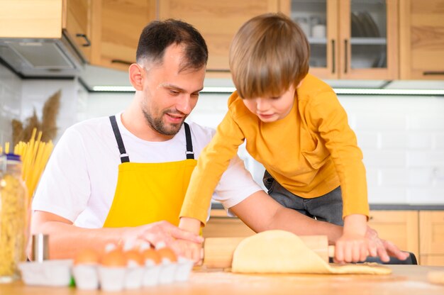 Father and son pressing the dough with the paddle