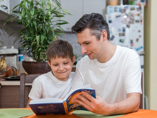 Father and son reading a book front view