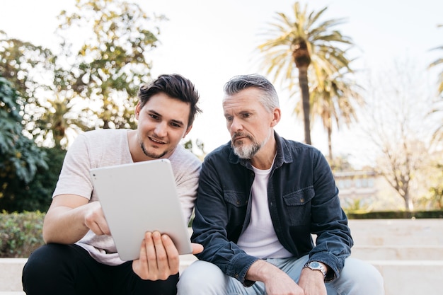 Father and son on stairs with tablet