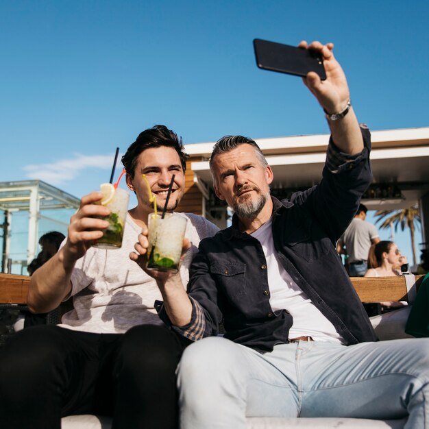 Father and son taking selfie in bar