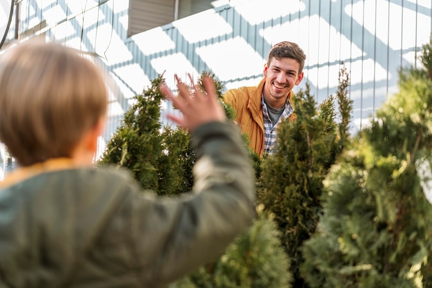 Father and son together at a tree nursery picking plant