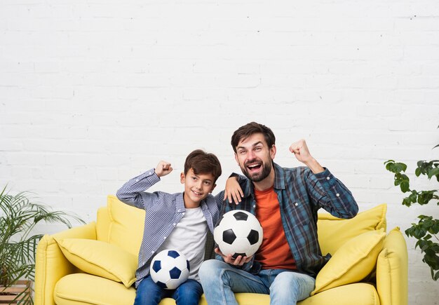 Отец и сын смотрят футбольный матч