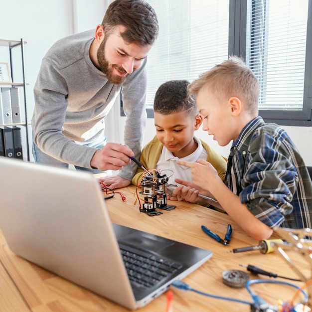 Free photo father and sons making robot