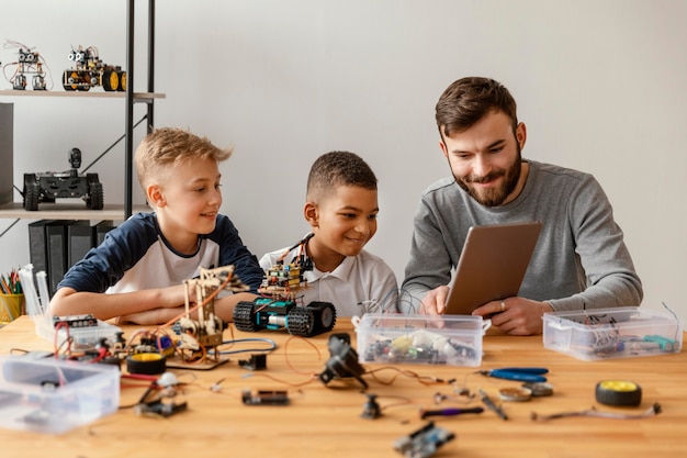 father and sons making robot