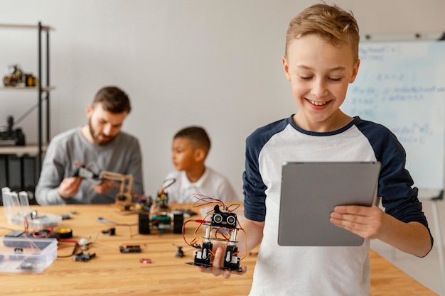 Free photo father and sons making robot