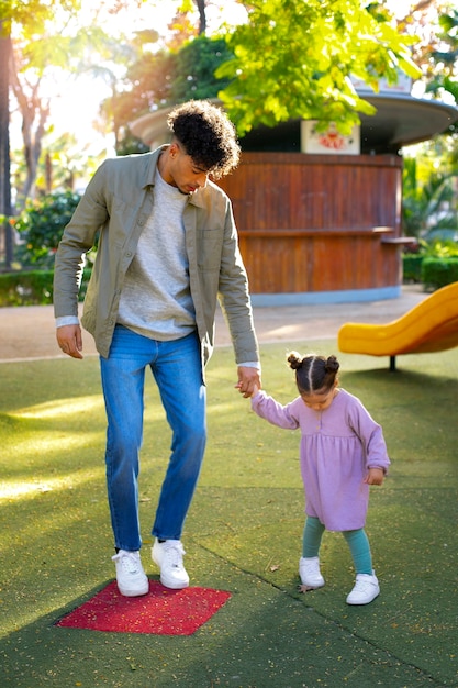 Foto gratuita padre che trascorre del tempo con sua figlia all'aperto il giorno del padre