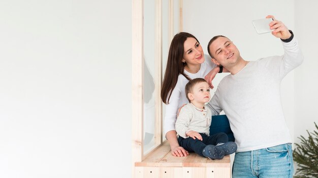 Father taking a selfie of family with mother and child