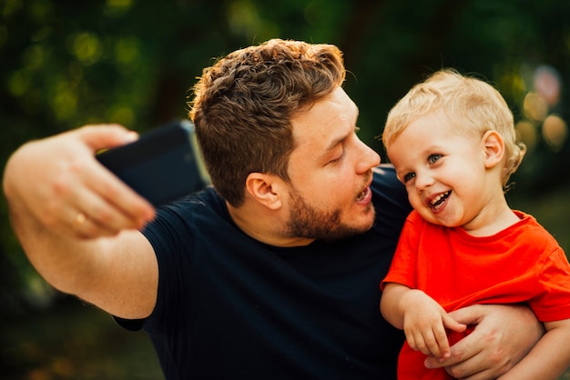 父はselfieを取って彼の子供を見て