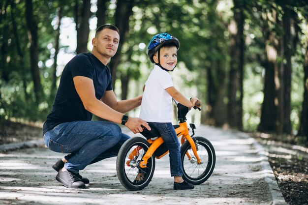 Father teaching his little son to ride a bicycle