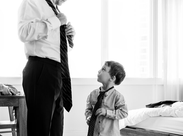 Father teaching son how to tie a tie